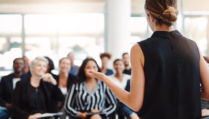woman standing in front of a sitting group upskilling and reskilling