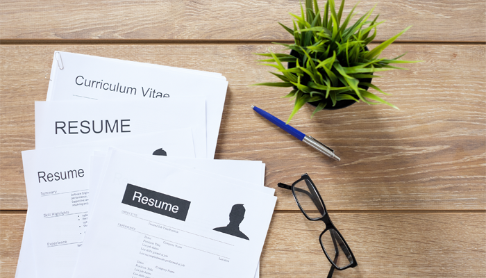 assorted resumes building on a desk