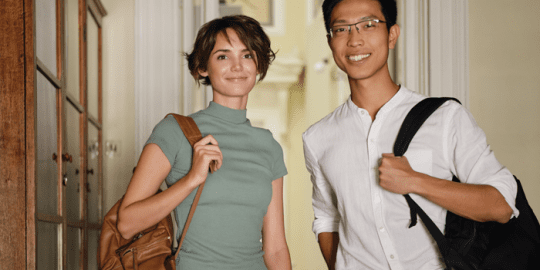 young caucasian woman and young asian man with glasses both holding bags indicating studying in canada as a foreign citizen