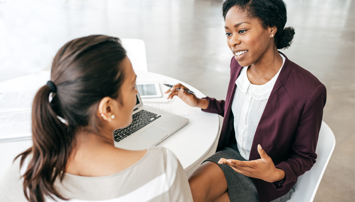 2 professional women sitting at a desk conducting an interview