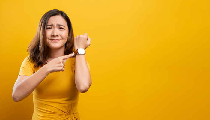 young asian woman pointing at wrist watch