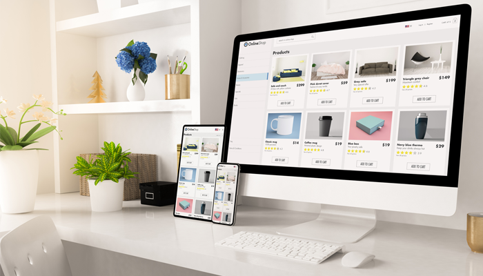 laptop and 2 mobile phones sitting a crisp white desk open to an ecommerce site