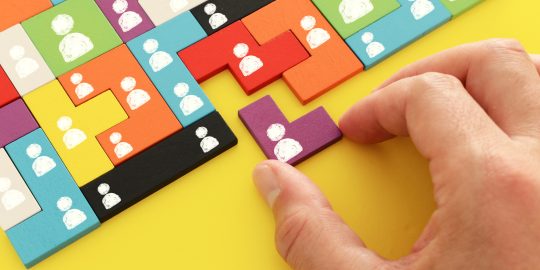 image of tangram puzzle blocks with people icons over wooden table ,human resources and management concept
