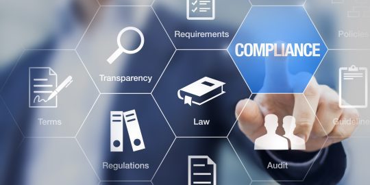Compliance concept with icons for regulations, law, standards, requirements and audit on a virtual screen with a business person touching a button