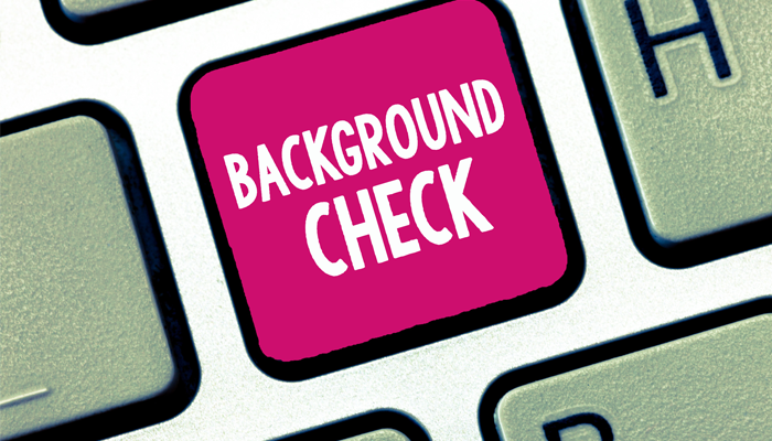 importance of a background check showcased with a pink key on a keyboard with the words background check on it