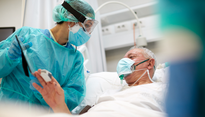 nurse in full PPE with patient assisting patient with mask on showcasing nursing jobs in canada