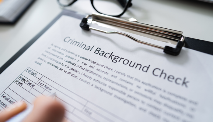clipboard with a criminal background check application form indicating the benefits of an online police check
