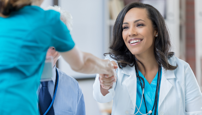 female doctor shaking hand of what appears to be a newly employed nurse showcasing background check solutions for the healthcare industry