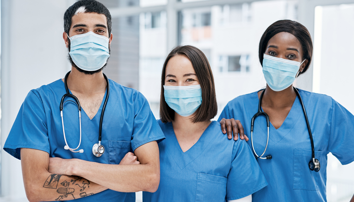 1 male and 2 female nurses standing side by side with masks on