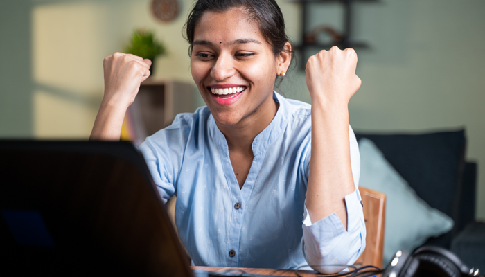 young happy indian woman with fights pointing up showcasing she has the best job