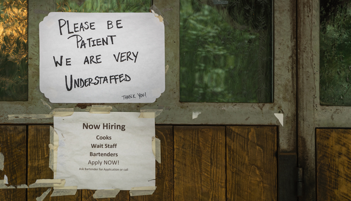hand written taped sign on establishment saying please be patient we are very understaffed and now hiring sign after omicron in canada and how it's affecting jobs