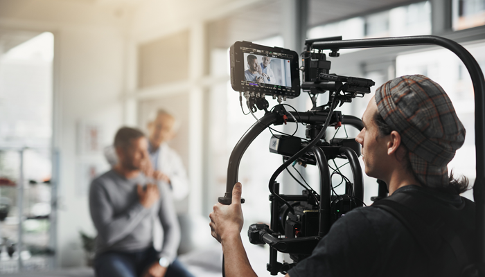 cameraman in the film industry jobs doing his work and filming a video of a doctor and patient advertising