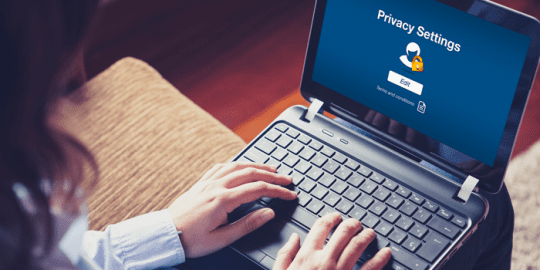 woman sitting with laptop on her lap with privacy settings on the screen