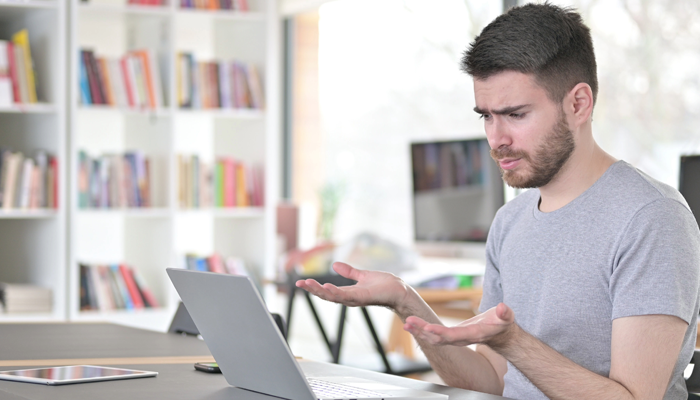 young man at computer looking at the ultimate job search guide