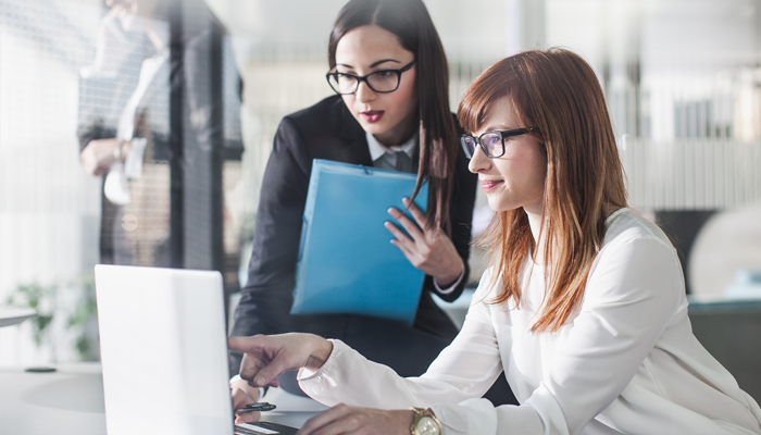 2 young women around computer overlooking recruiting software