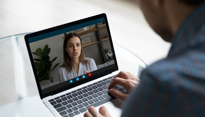 blurred man facilitating a zoom call with a young woman indicating an exit interview