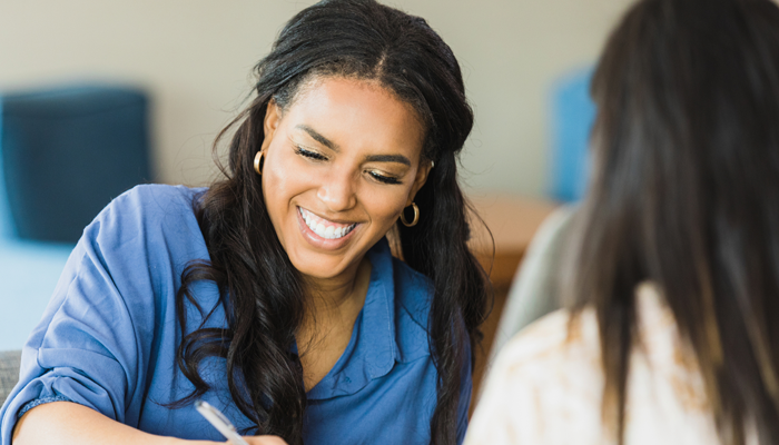 african american woman signing job acceptance after her pre-employment screening