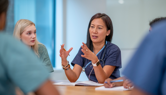 nurses sitting around at a roundtable discussing nursing job opportunities