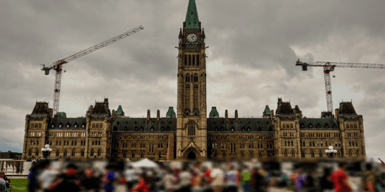 blurred crowd of people standing in front of parliament indicating requirement for a criminal record check in ottawa government jobs