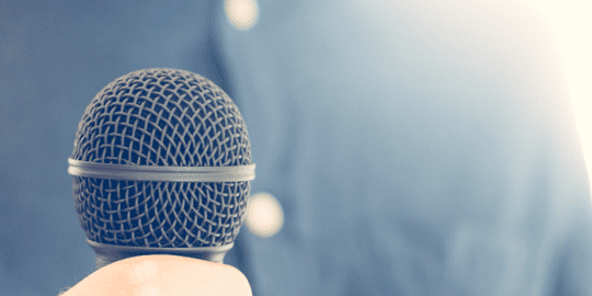 close up image of microphone showcasing announcement for Lawrence Franco newly appointed President for Triton